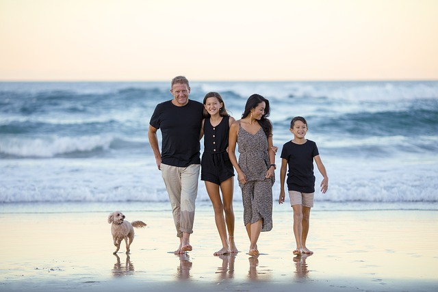 famiglia composta dai genitori e due figli che passeggia sul lungomare con il loro cane